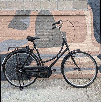 Black Omafiets against painted brick mural